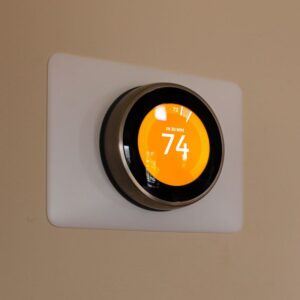a smart thermostat with yellow lighting and set to 74 degrees